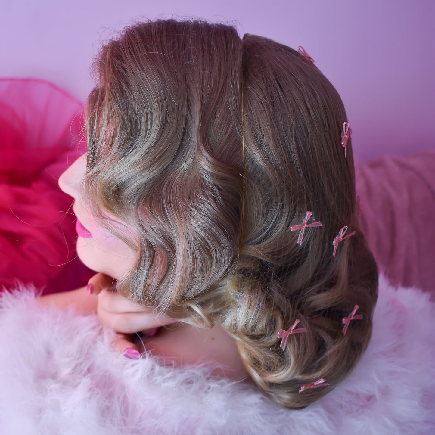 Person with styled hair on a pink and white background