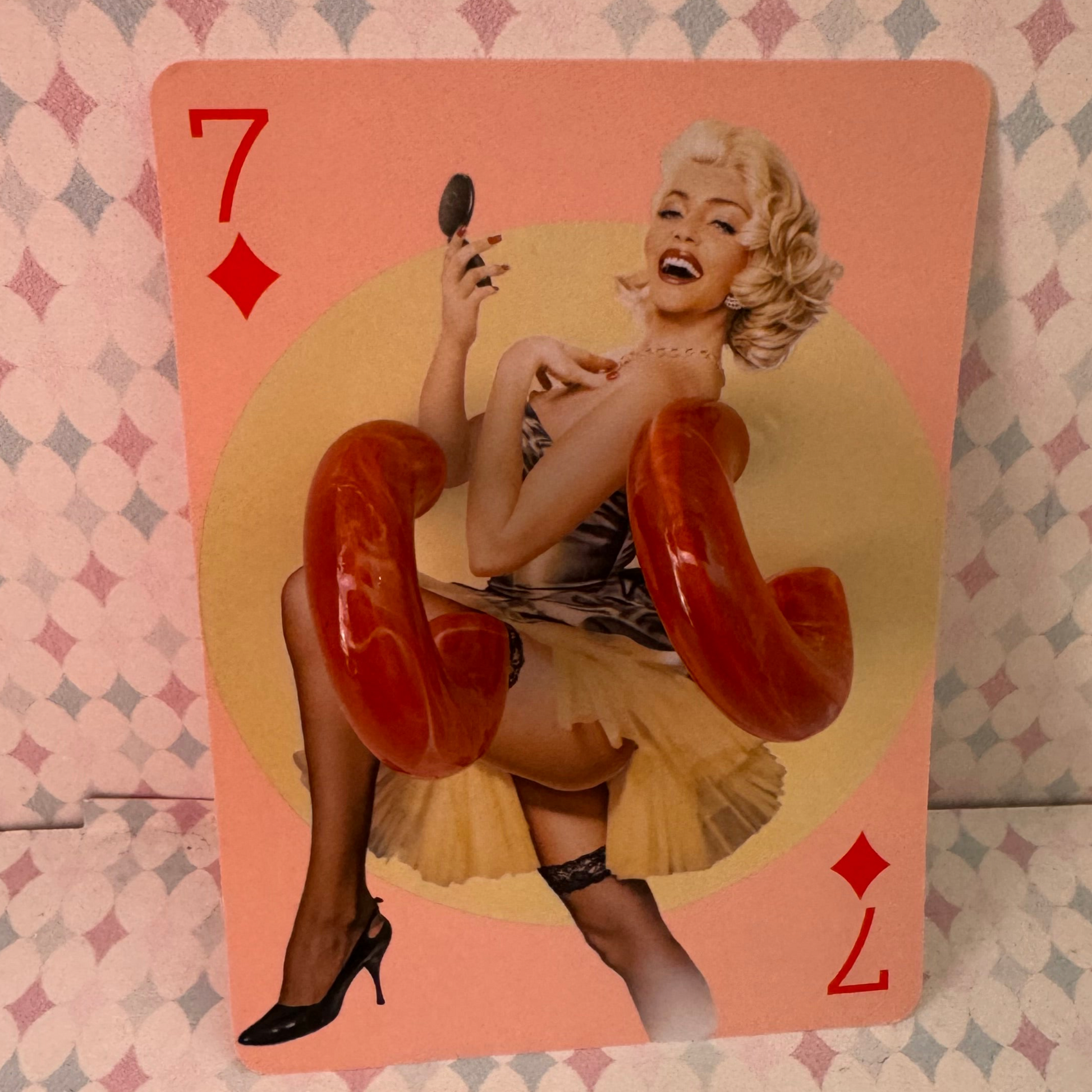 Playing card with a stylized illustration of a woman holding a phone, on a patterned background.