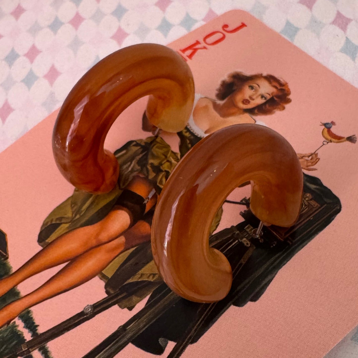 Vintage-style playing card with a woman and telephone on a patterned surface