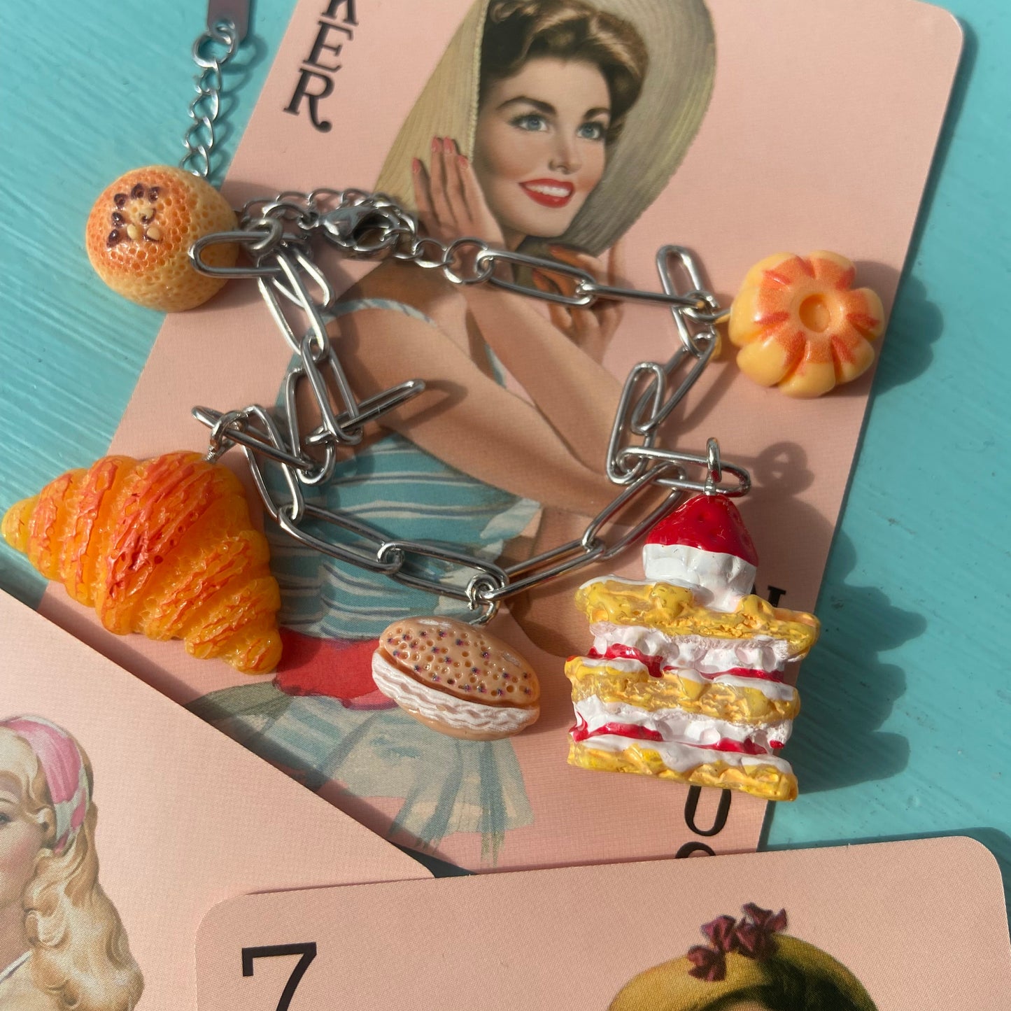 Silver charm bracelet on a card with a vintage-style illustration of a woman.