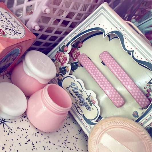 Collection of lip balm containers and a small box on a textured surface with decorative elements.