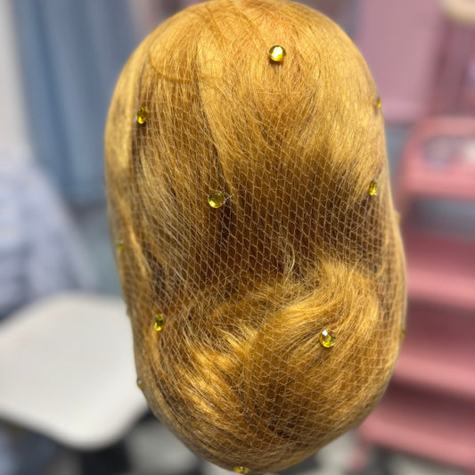 Brown hair on a mannequin head with pins, blurred background